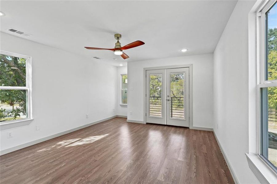 Unfurnished room with french doors, plenty of natural light, wood finished floors, recessed lighting, and a ceiling fan