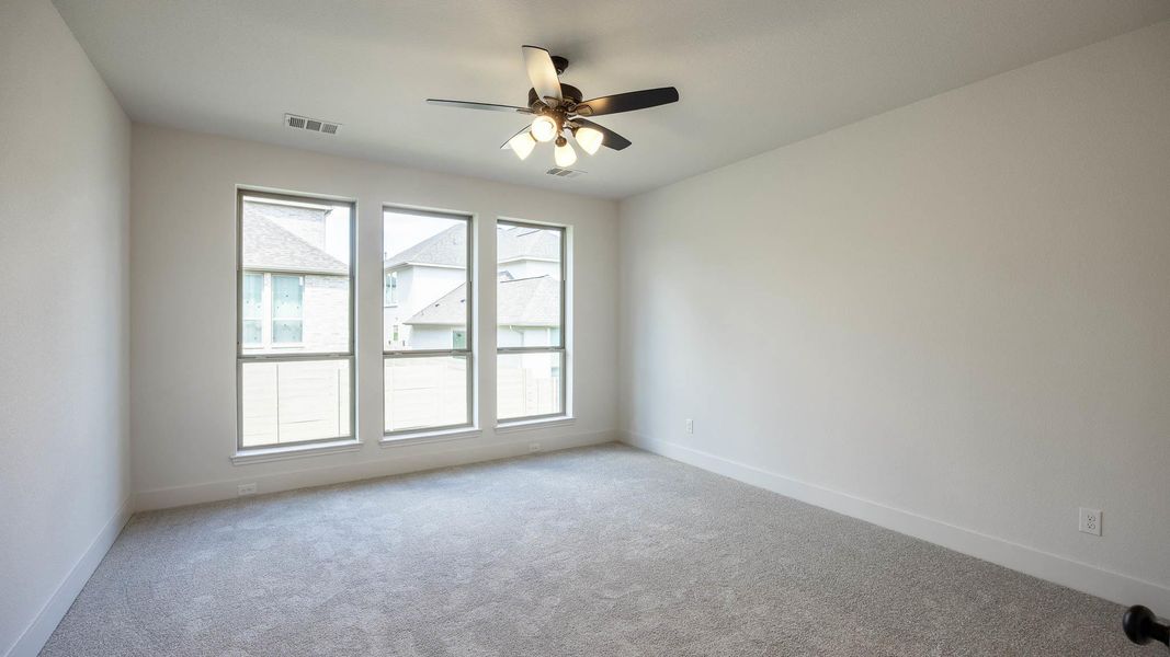 Carpeted empty room featuring baseboards and ceiling fan Carpeted empty room featuring baseboards and ceiling fan