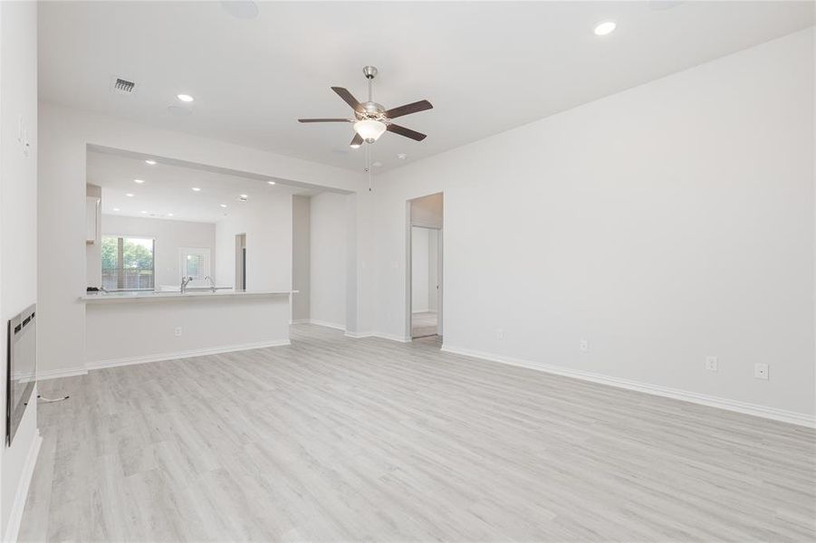 Unfurnished living room featuring light wood-type flooring and ceiling fan