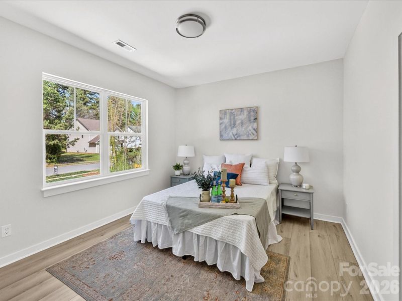 Spacious and light-filled primary suite featuring large windows, neutral finishes, and a comfortable layout perfect for rest and relaxation. Spacious and light-filled primary suite featuring large windows, neutral finishes, and a comfortable layout perfect for rest and relaxation.