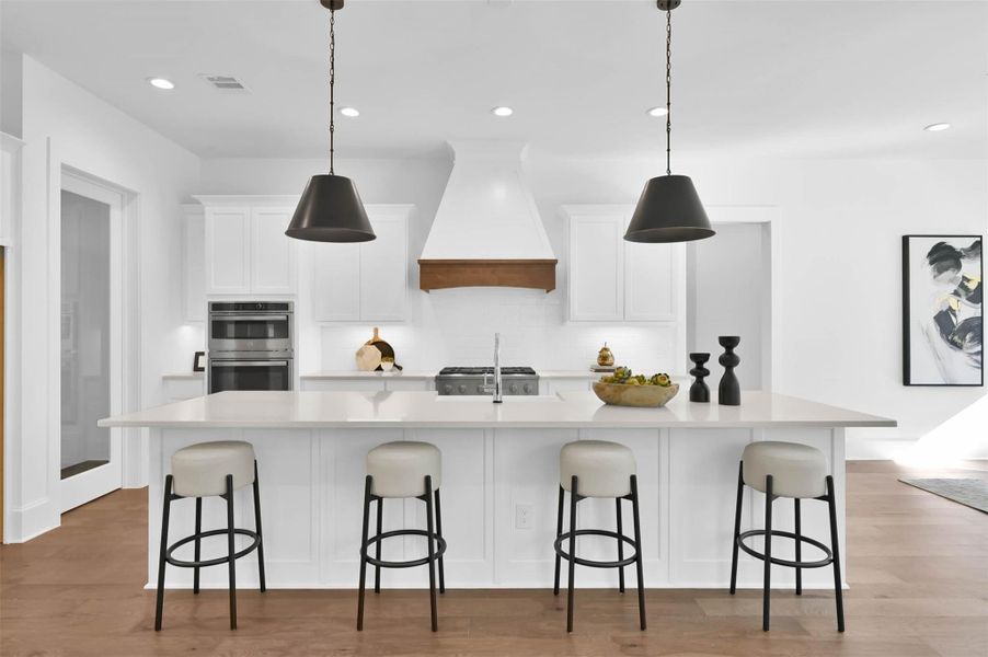 Exquisite kitchen with white custom cabinets, black accents and large central island with seating. Exquisite kitchen with white custom cabinets, black accents and large central island with seating.
