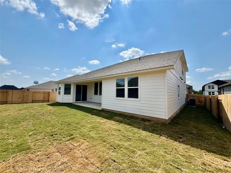 Back of house featuring a patio area, a fenced backyard, and a shingled roof
