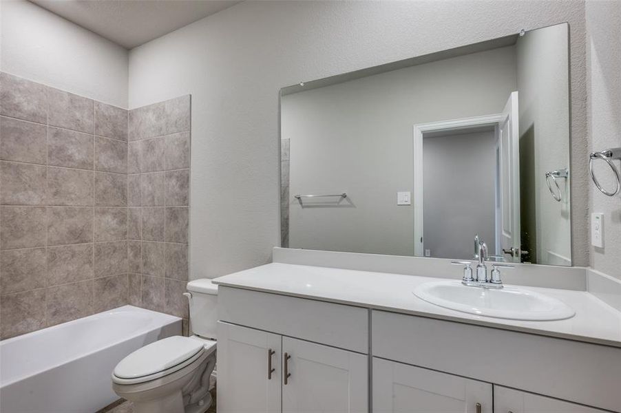 Full bathroom with vanity, shower / tub combination, and a textured wall