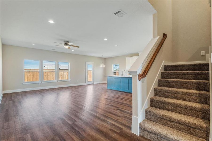 Unfurnished living room featuring ceiling fan, dark hardwood / wood-style flooring, and sink Unfurnished living room featuring ceiling fan, dark hardwood / wood-style flooring, and sink