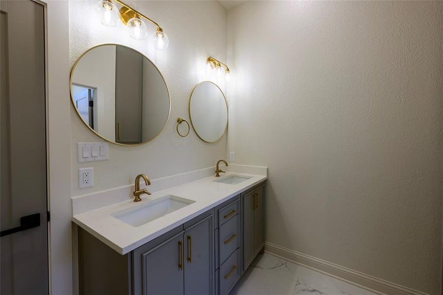 Bathroom with double vanity and light marble finish floors Bathroom with double vanity and light marble finish floors
