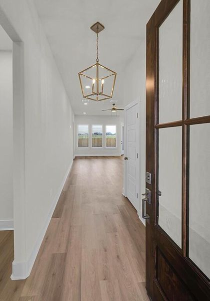 Hallway featuring a chandelier and light wood-type flooring