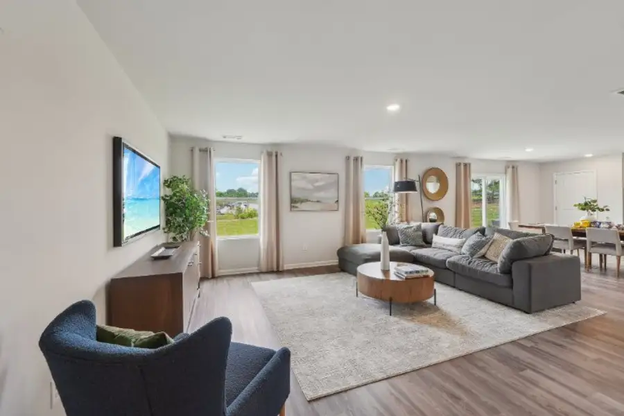 A living room with a tv and couches. A living room with a tv and couches.