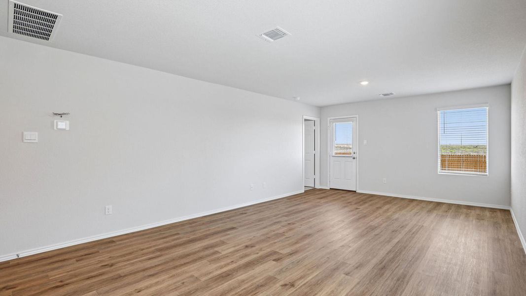 A versatile living space with light wood-style flooring and abundant natural light invites comfortable living.