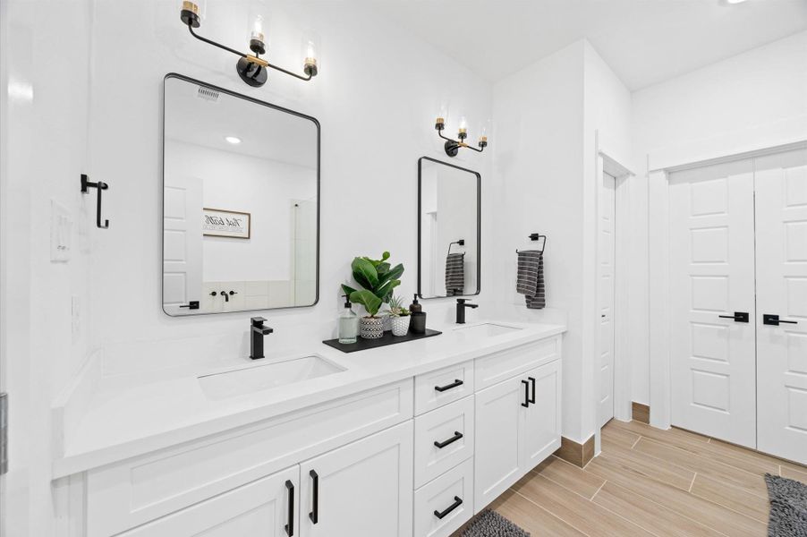 A well-appointed primary bathroom features a spacious layout with elegant finishes. A double-sink vanity provides ample counter space and storage, complemented by stylish fixtures and mirrors that reflect the room’s bright, airy feel. A well-appointed primary bathroom features a spacious layout with elegant finishes. A double-sink vanity provides ample counter space and storage, complemented by stylish fixtures and mirrors that reflect the room’s bright, airy feel.