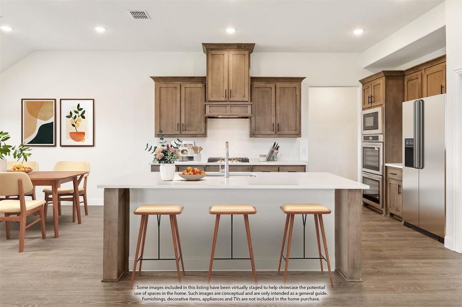 Kitchen with large island, three bar stools, brown cabinets, stainless steel appliances, and adjacent dining area