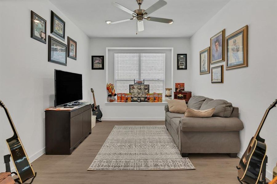Living room featuring light wood-style flooring and a ceiling fan