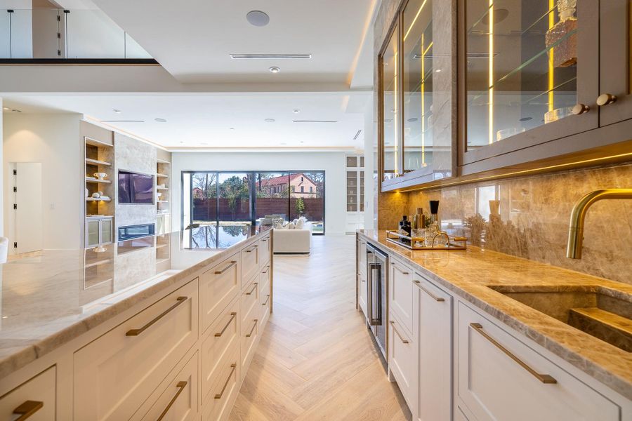 Custom wet bar featuring built-in cabinetry, designer backsplash, and beverage storage — ideal for entertaining. Custom wet bar featuring built-in cabinetry, designer backsplash, and beverage storage — ideal for entertaining.