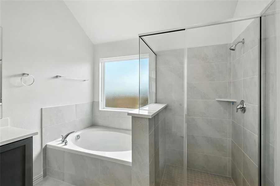 Bathroom featuring a bath, vanity, a stall shower, and vaulted ceiling Bathroom featuring a bath, vanity, a stall shower, and vaulted ceiling