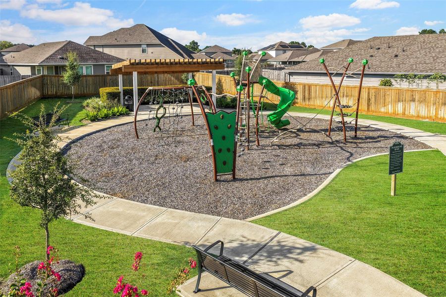 Charming community playground with modern equipment and a covered seating area, perfect for family fun and relaxation.