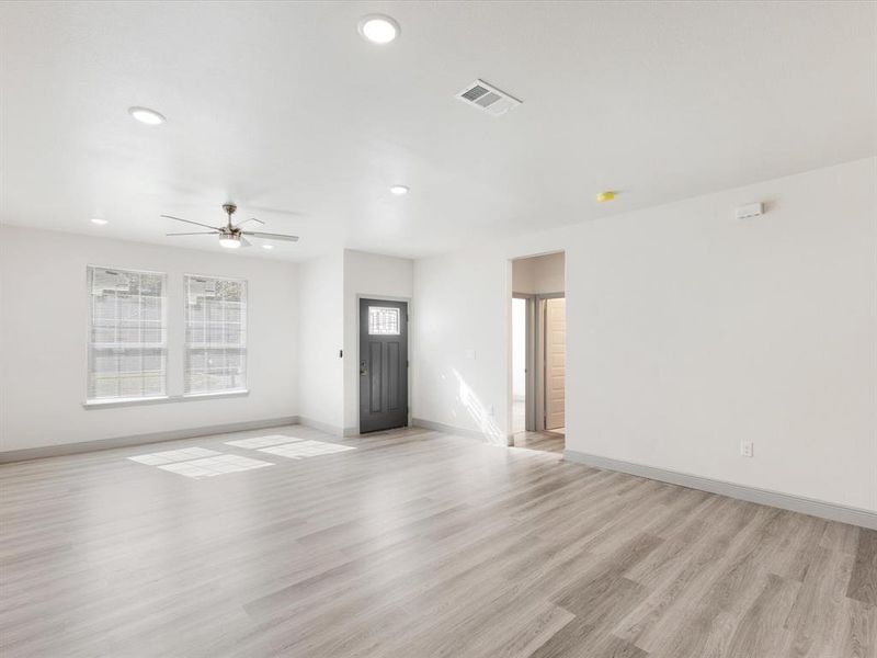 Unfurnished living room with light wood-style floors, ceiling fan, and recessed lighting
