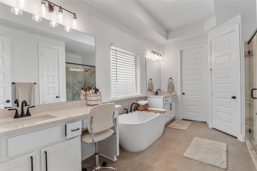 Primary Bathroom featuring a soaking tub, a shower stall, two vanities, and light tile patterned floors Primary Bathroom featuring a soaking tub, a shower stall, two vanities, and light tile patterned floors
