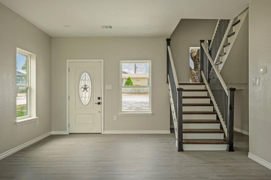 Entrance foyer featuring stairway and light wood-style floors