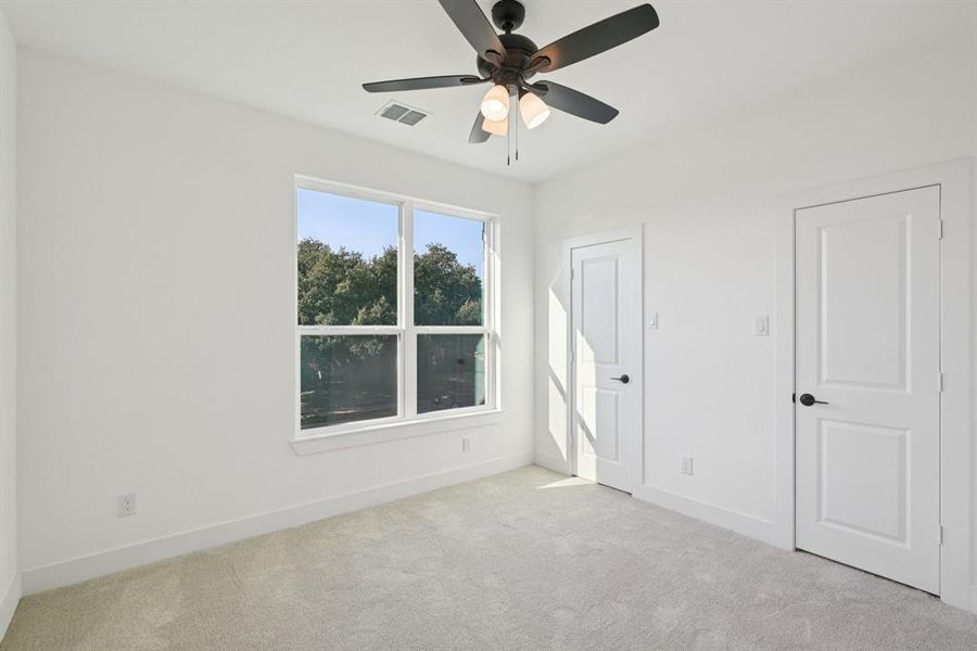 Unfurnished bedroom with carpet flooring and a ceiling fan