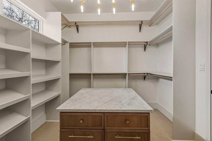 Walk in closet with light wood-type flooring