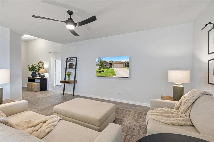 Living room with vinyl wood floors, a ceiling fan, and baseboards Living room with vinyl wood floors, a ceiling fan, and baseboards