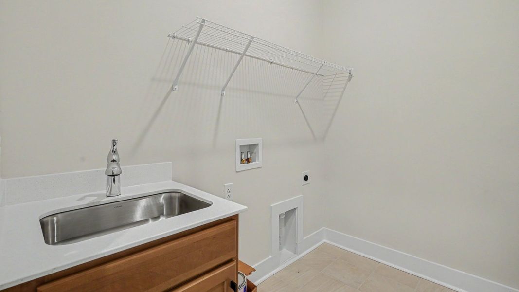 Dedicated laundry room with sink and ventilated shelf