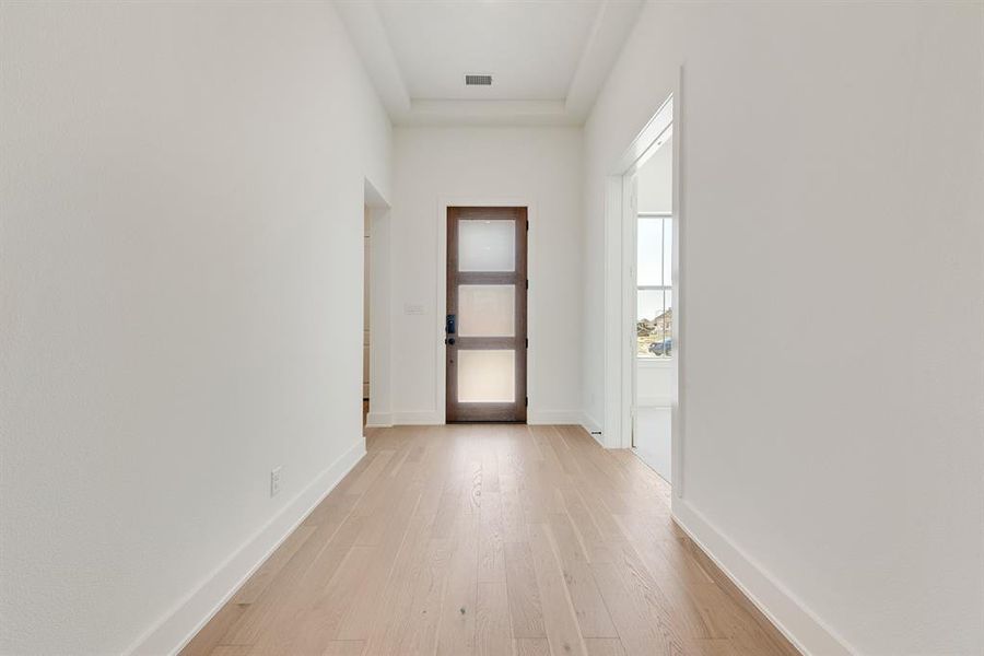 Corridor with light wood-type flooring and baseboards Corridor with light wood-type flooring and baseboards