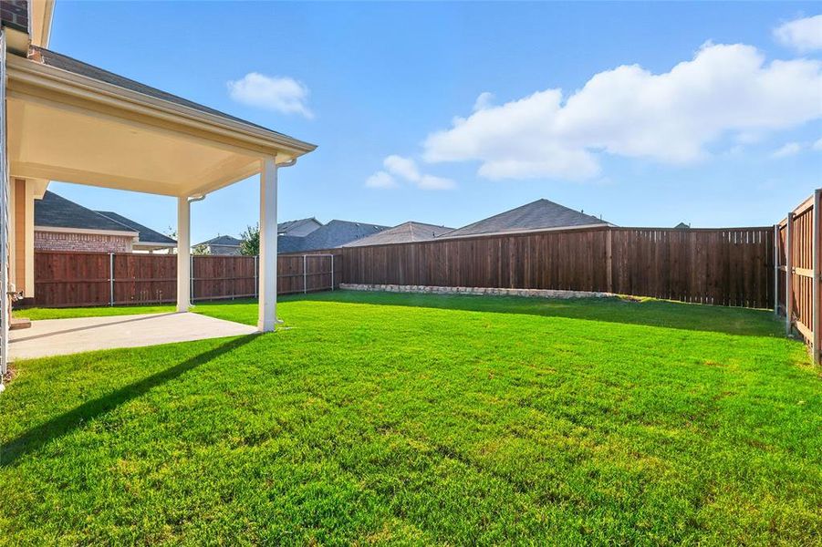 Fenced backyard with a patio area Fenced backyard with a patio area