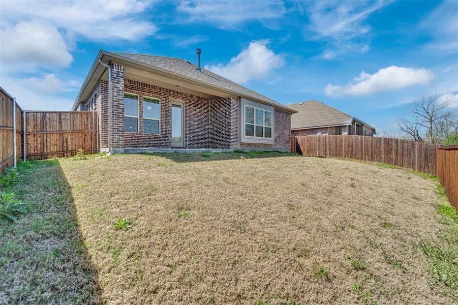 Back of house with a patio area, a fenced backyard, brick siding, and a shingled roof