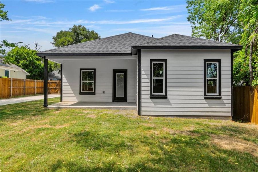 Rear view of house with a patio and a lawn