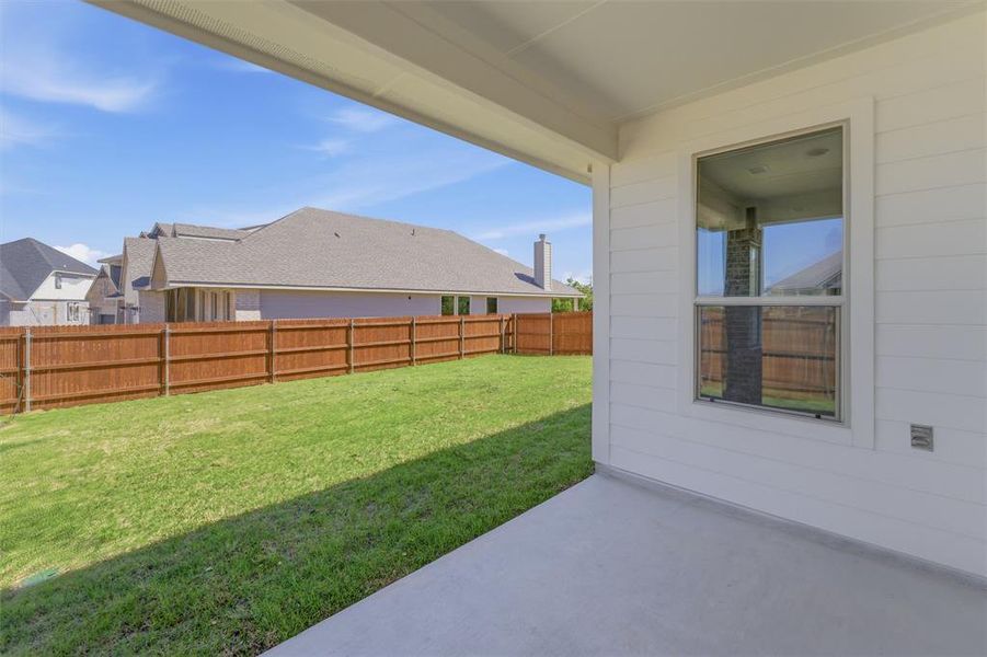 Fenced backyard with a patio area and a residential view