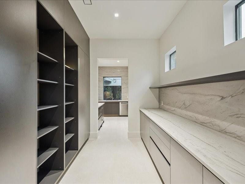 Pantry includes custom built-ins that transition smoothly into the prep kitchen for seamless storage and design continuity.
