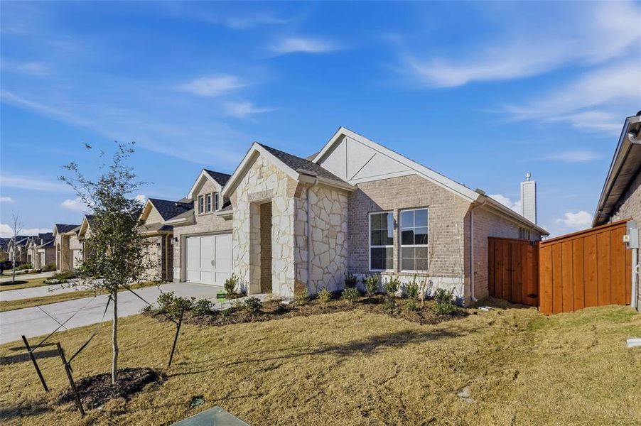 View of front of home featuring concrete driveway, stone siding, brick siding, a chimney, and a garage