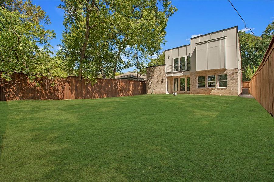 Rear view of property with a yard