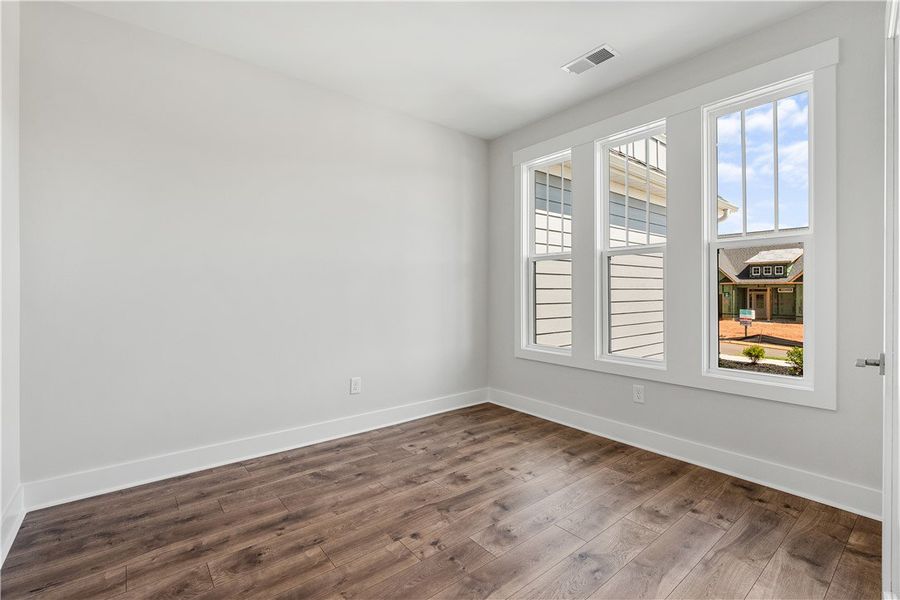 Sun-filled room with rich hardwood-style flooring