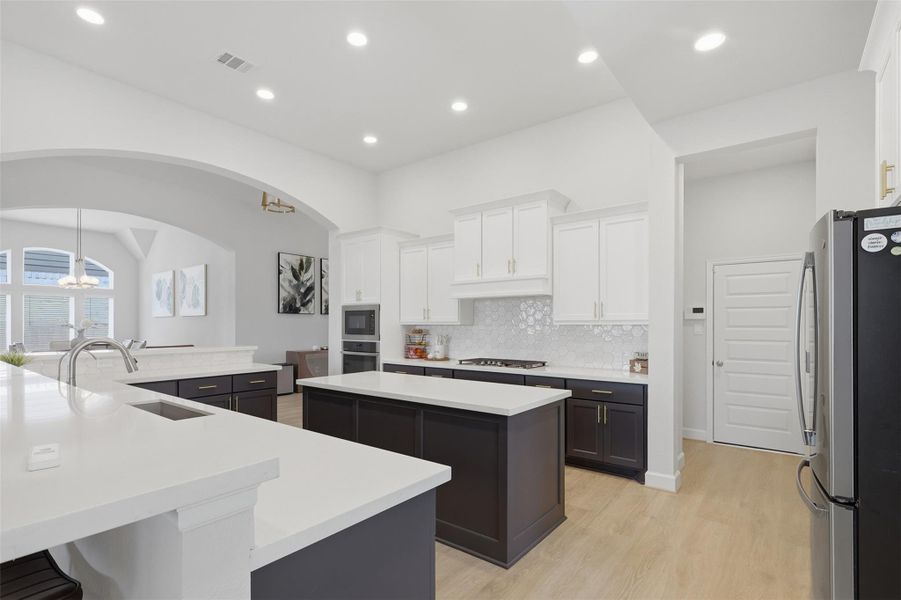 Elegant kitchen featuring a spacious island with quartz countertops, gas cooktop, and ample cabinetry, all under bright recessed lighting. Elegant kitchen featuring a spacious island with quartz countertops, gas cooktop, and ample cabinetry, all under bright recessed lighting.