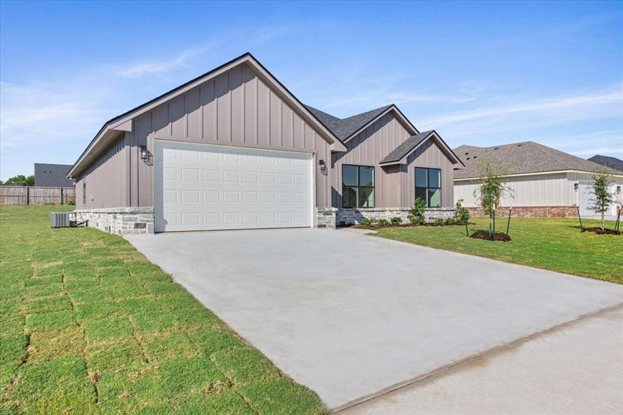 View of front of home with board and batten siding, driveway, and a garage View of front of home with board and batten siding, driveway, and a garage