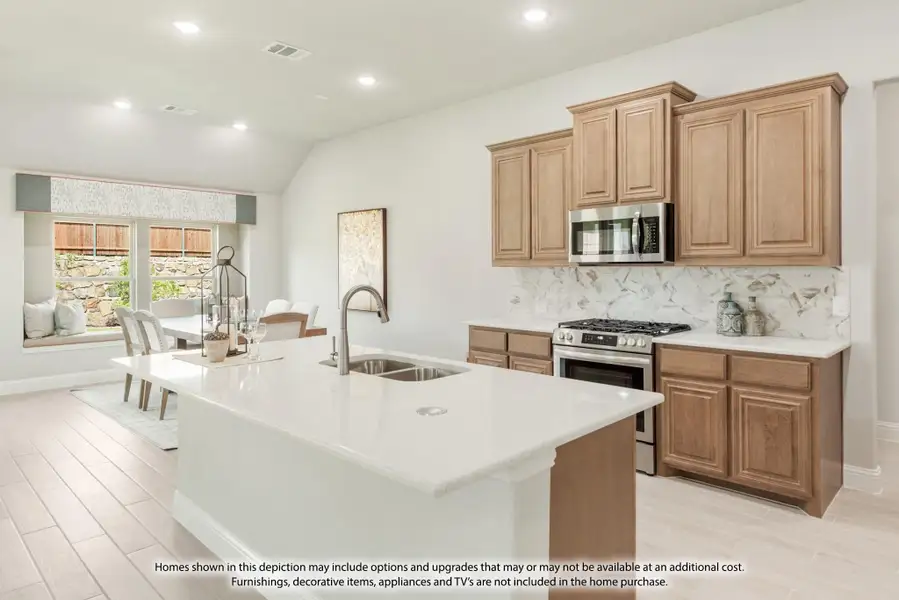 Kitchen with large white island, brown cabinets, marble backsplash, and stainless steel appliances Kitchen with large white island, brown cabinets, marble backsplash, and stainless steel appliances