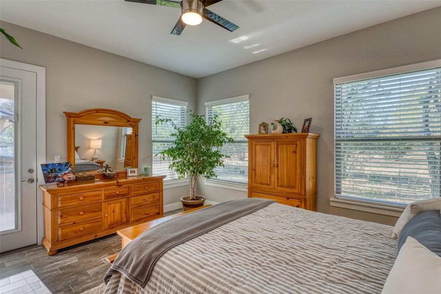 Bedroom featuring wood finish floors, a ceiling fan, and access to exterior