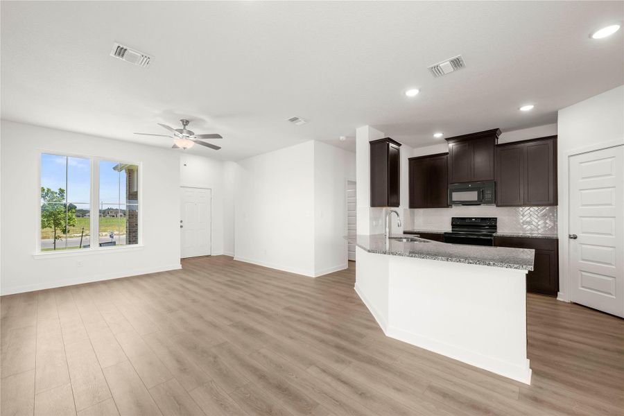 An open concept living area transitions seamlessly to a well-appointed kitchen, ideal for entertaining. An open concept living area transitions seamlessly to a well-appointed kitchen, ideal for entertaining.