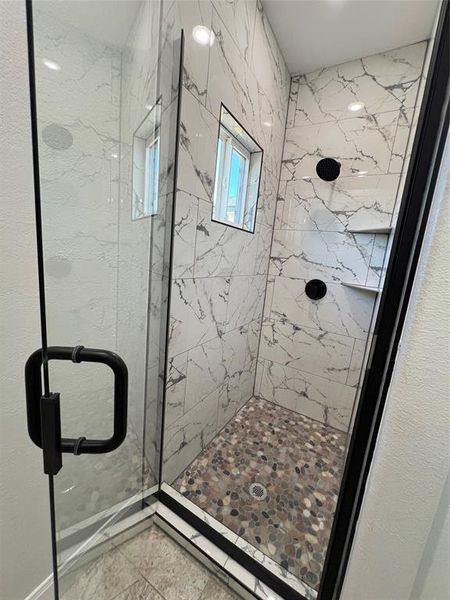 Full bathroom featuring a marble finish shower and marble finish floor