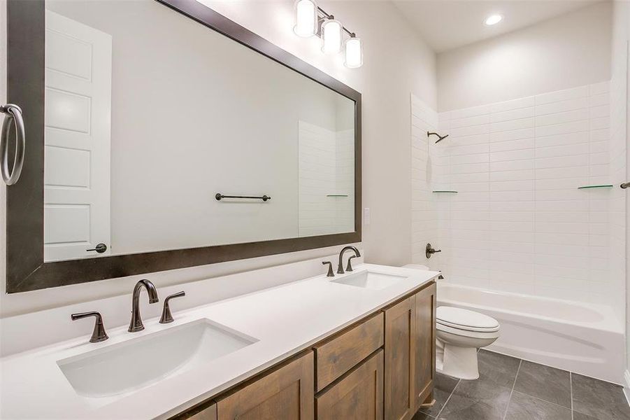 Full bathroom with tile patterned flooring, vanity, toilet, and tiled shower / bath