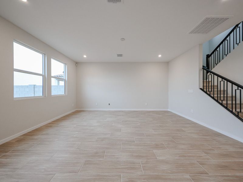 A room with a staircase and windows.