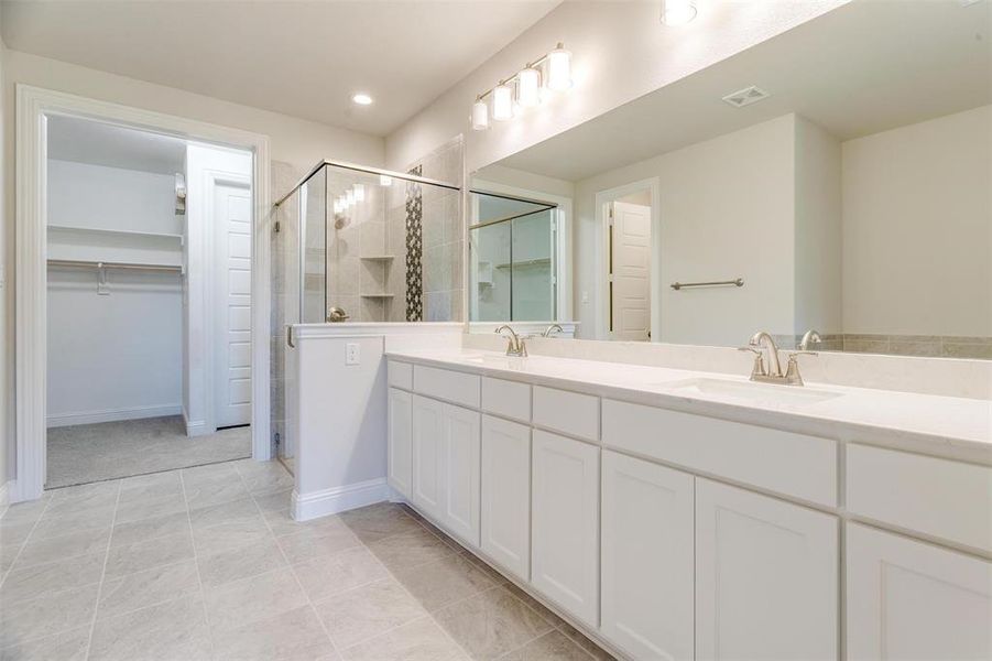 Bathroom with vanity, tile patterned floors, and a shower with door