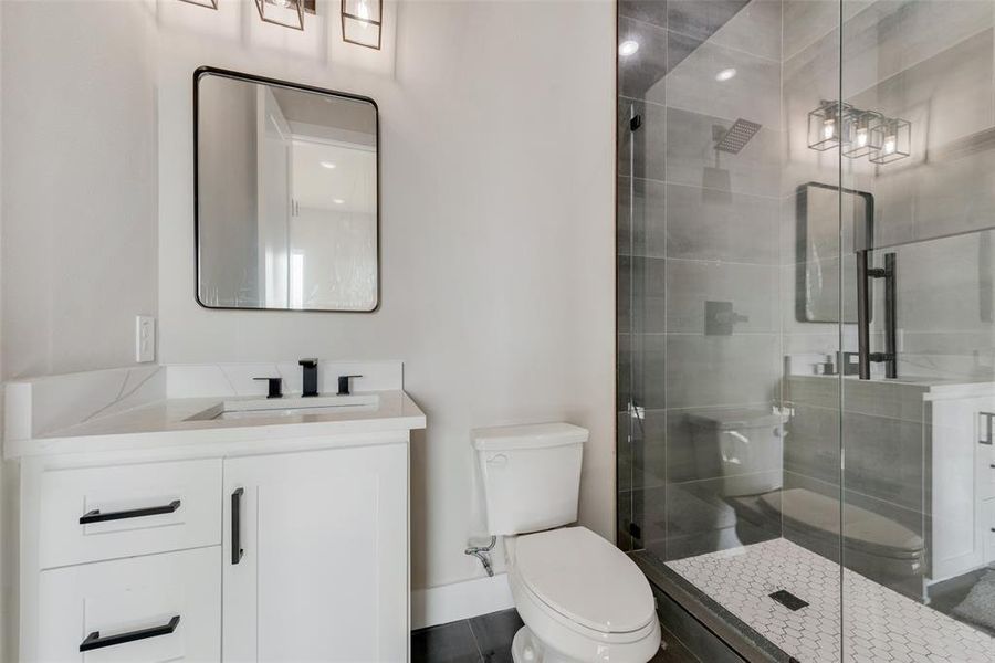 Bathroom with a shower with shower door, toilet, and vanity