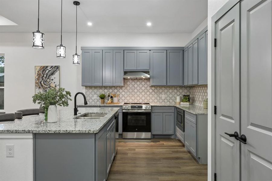 Contemporary kitchen featuring gray shaker-style cabinetry and a mosaic tile backsplash
