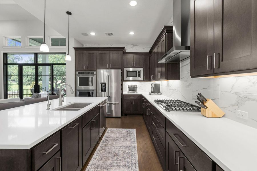 Culinary excellence awaits in this kitchen, featuring an expansive island with ample seating and top-tier appliances.
