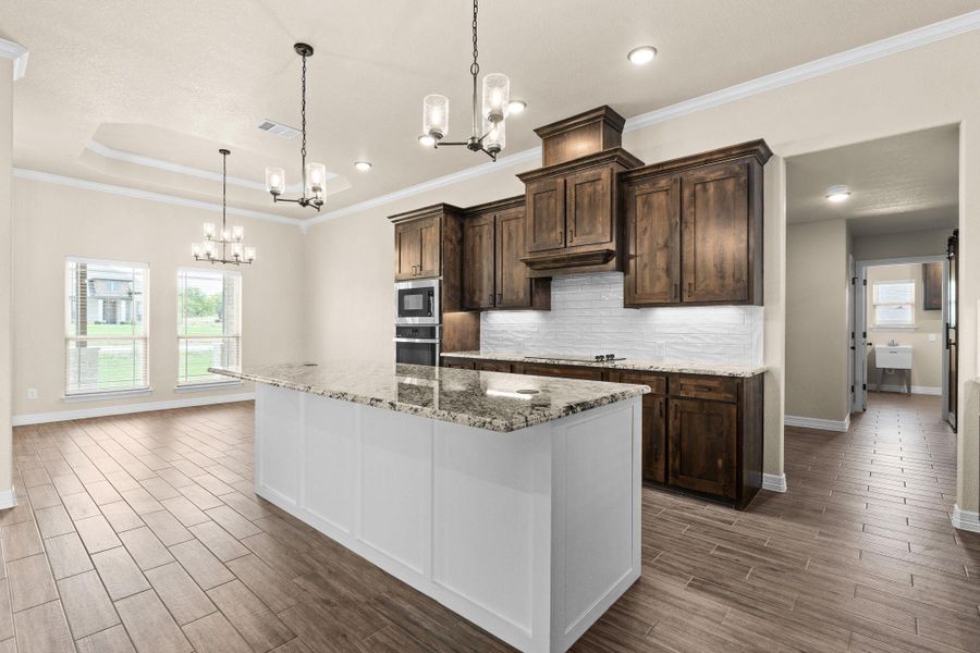 Kitchen featuring crown molding, hanging light fixtures, backsplash, granite countertops, and recessed lighting Kitchen featuring crown molding, hanging light fixtures, backsplash, granite countertops, and recessed lighting