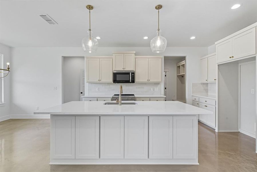 Kitchen featuring concrete flooring, decorative backsplash, hanging light fixtures, and recessed lighting