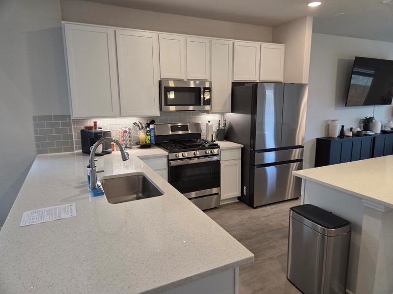 Modern kitchen featuring light-toned cabinetry and light-toned countertops