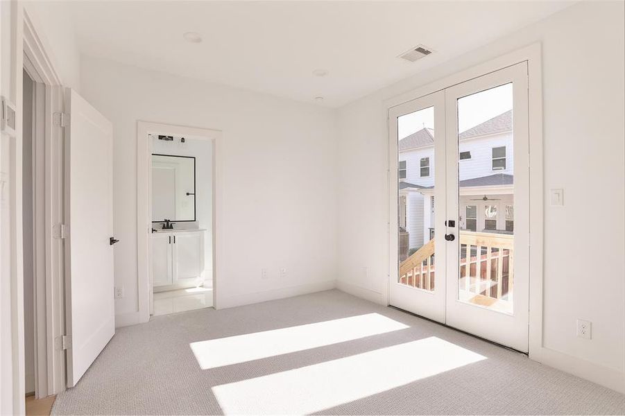 A secondary bedroom on the lower level offers direct access to the backyard and a balcony through French doors. This versatile space can be tailored to your needs, such as a home office or guest room.